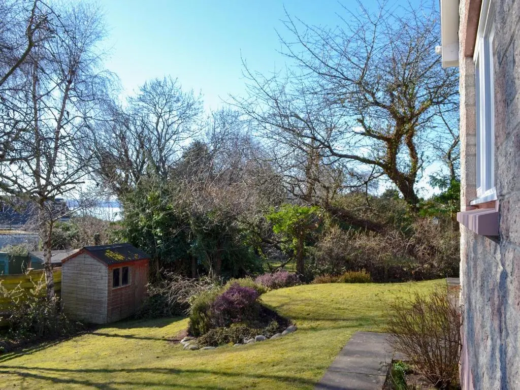 a house with a yard with a dog house at Wester Links in Fortrose