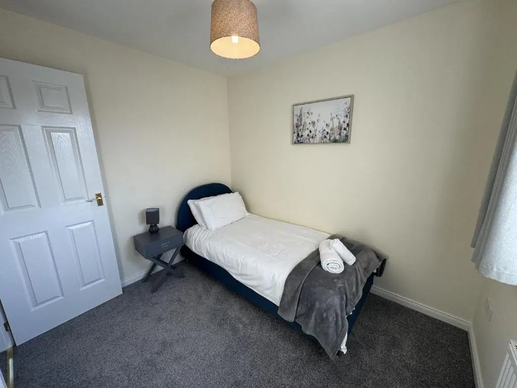 a small bedroom with a bed and a lamp at No 25 Inverness - Home from Home in the Highlands in Inverness