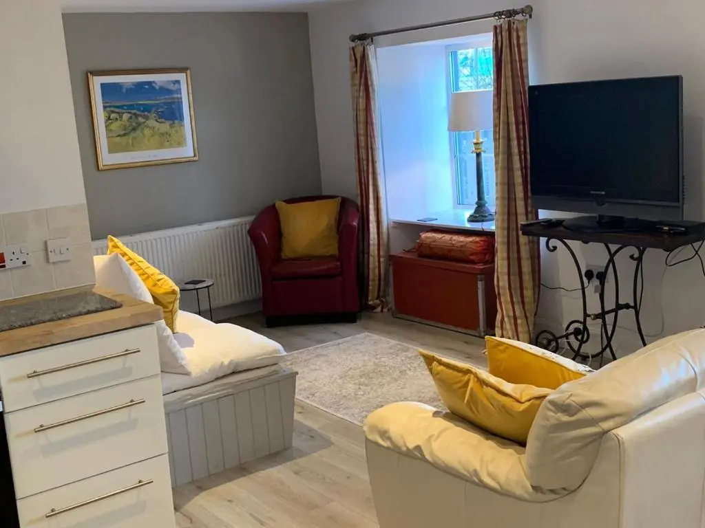 a living room with a couch and a tv at Hill House - Mews Town House, in a quiet private close, in the City Centre of Inverness. in Inverness