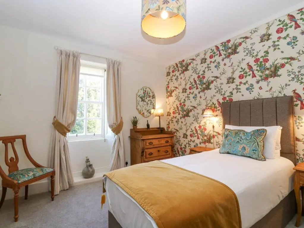 a bedroom with a bed with floral wallpaper at North Wing - Pitmedden Gardens in Ellon