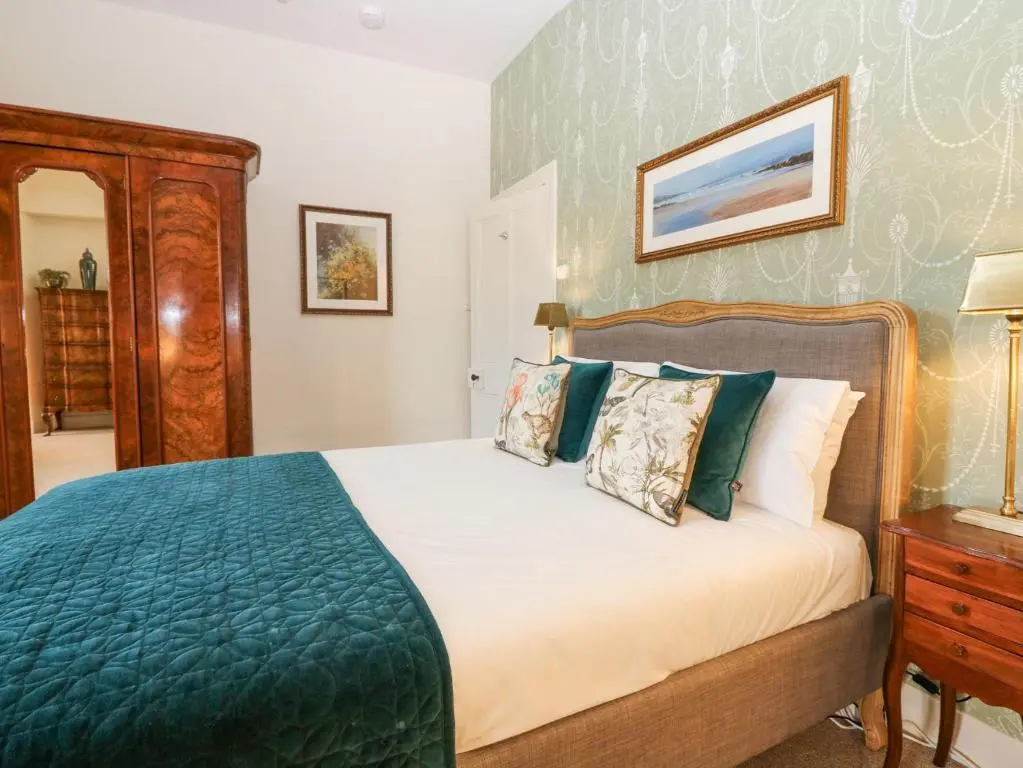a bedroom with a bed with a blue blanket at North Wing - Pitmedden Gardens in Ellon