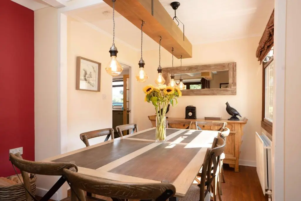 a dining room with a wooden table and chairs at Kinloch Lodge in Bearnock