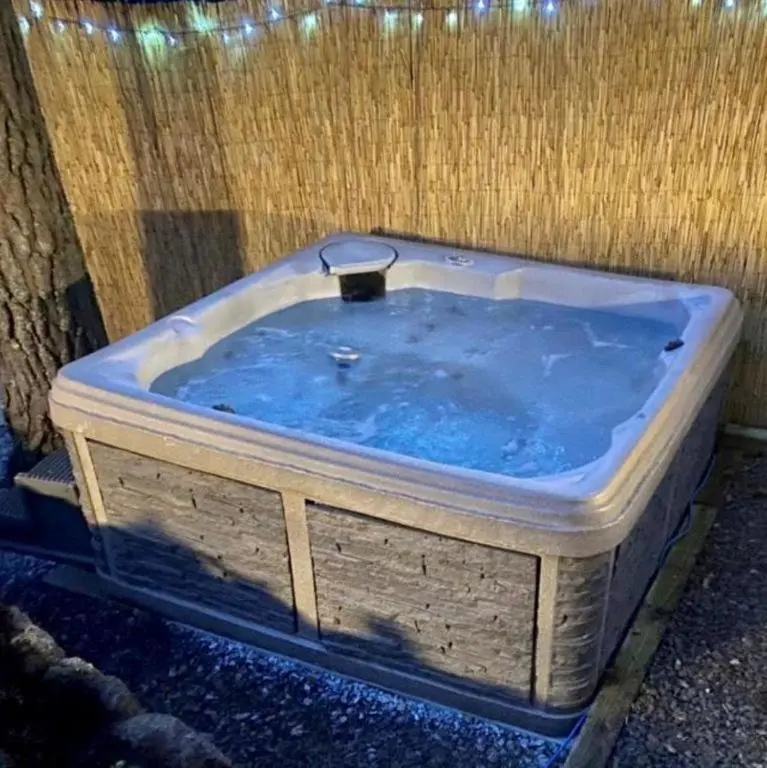 a jacuzzi tub sitting next to a fence at Wildcat Lodge in Boat of Garten