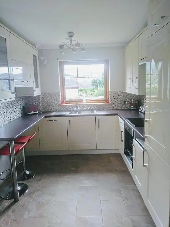 a kitchen with white cabinets and a sink and a window at Rooms at The Cooperage in Auchleven