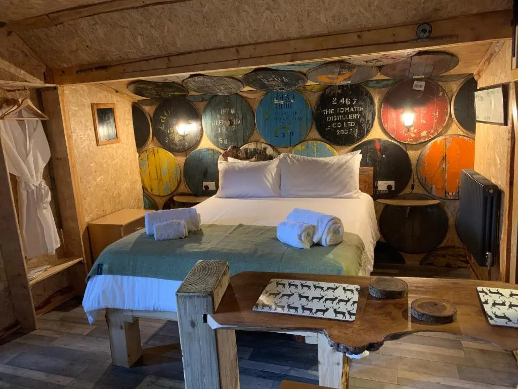 a bedroom with a bed and a wall of wine barrels at The Bothy Aberlour in Aberlour