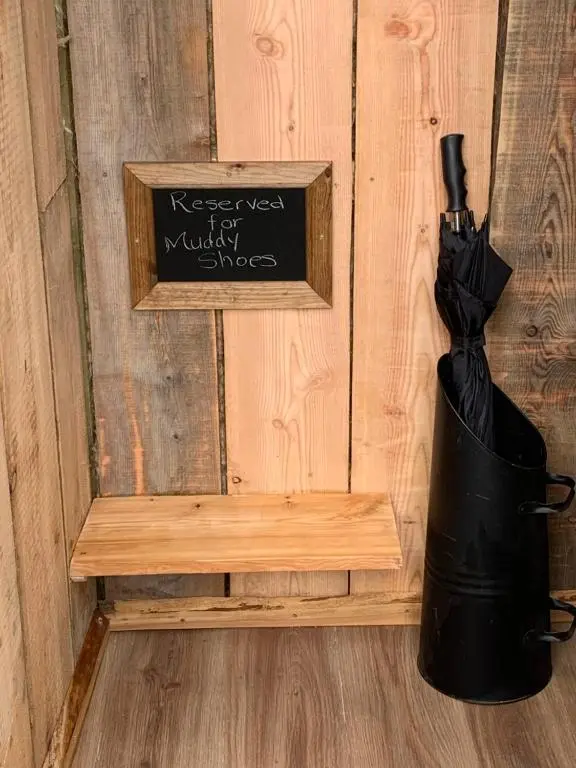a black umbrella sitting on a bench next to a sign at The Bothy Aberlour in Aberlour