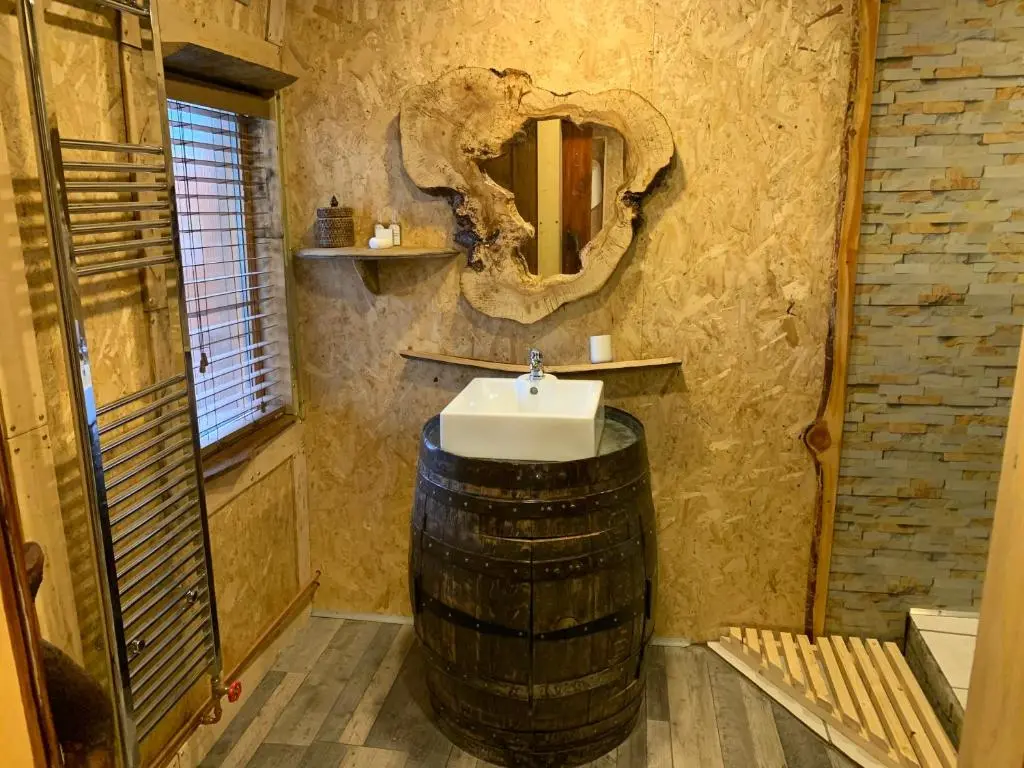 a bathroom with a sink in a barrel with a mirror at The Bothy Aberlour in Aberlour