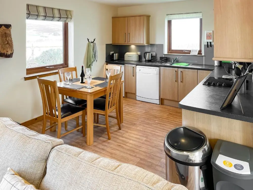 a kitchen and dining room with a table and chairs at The Barn in Lairg
