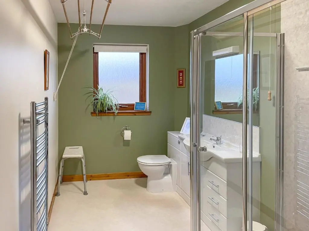 a bathroom with a toilet and a sink at The Barn in Lairg