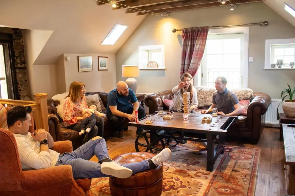 a group of people sitting in a living room at The Maltings - lodge with hot tub in Nethy Bridge