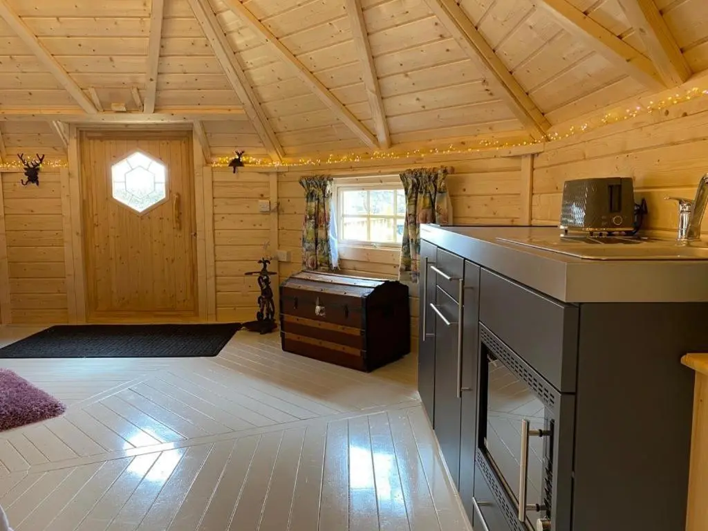 a room with a kitchen and a living room at Woodland Lodge Oxen Craig in Kintore