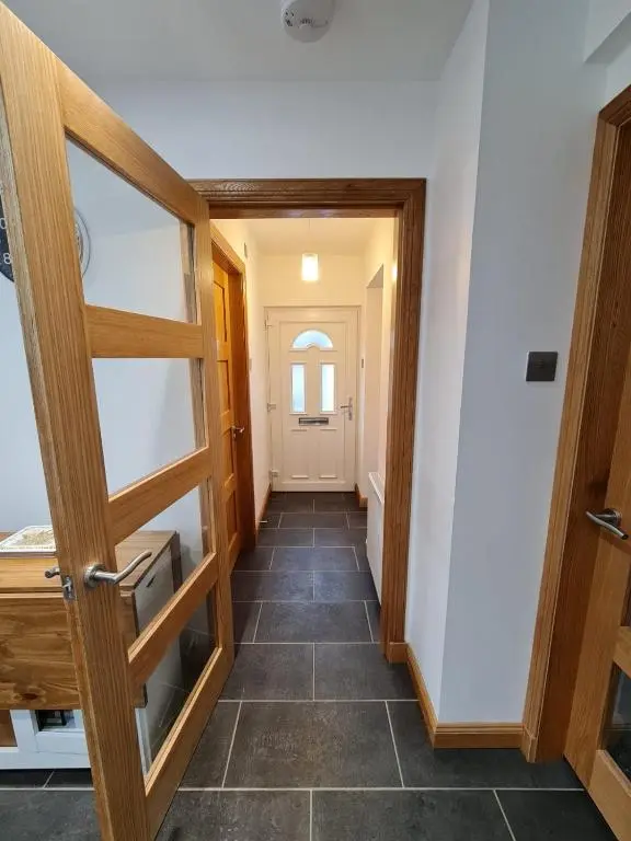 a hallway with a door and a tile floor at Bruxie Holiday Cottages - Honeysuckle Cottage in Maud