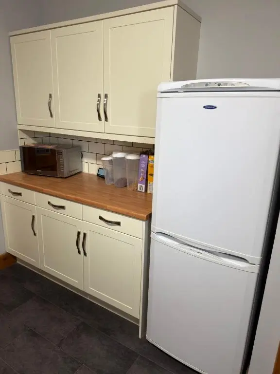 a kitchen with white cabinets and a white refrigerator at Newly Refurbished 2 Bedroom flat on NC500 route in Wick