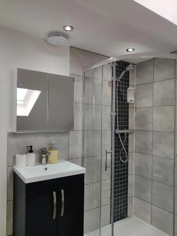 a bathroom with a sink and a shower at Signature Apartments in Fraserburgh