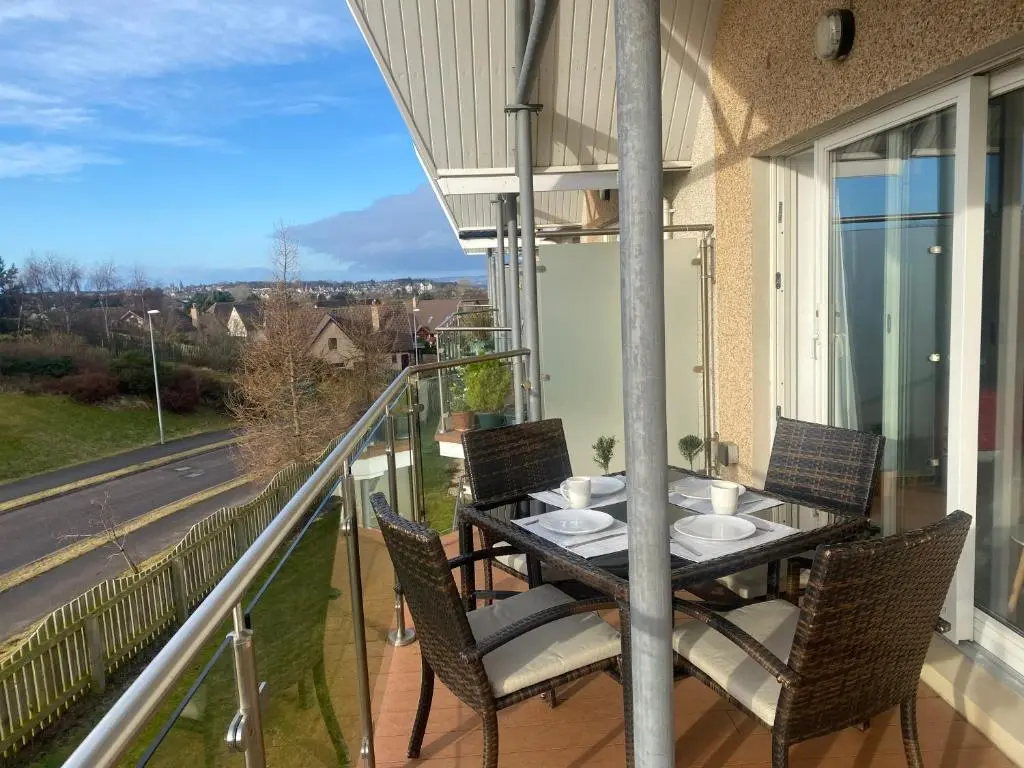 a porch with a table and chairs on a balcony at The Duplex Nairn- Spacious 3 Bedroom with sunny balcony in Nairn