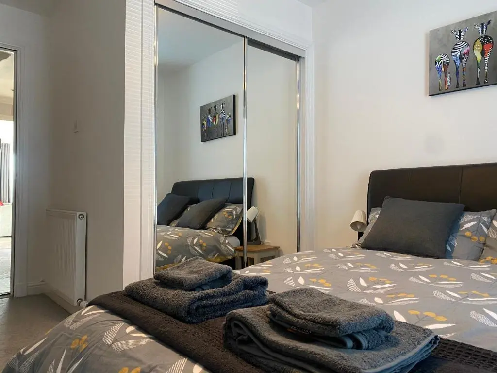 a bedroom with a bed with towels on it at The Duplex Nairn- Spacious 3 Bedroom with sunny balcony in Nairn
