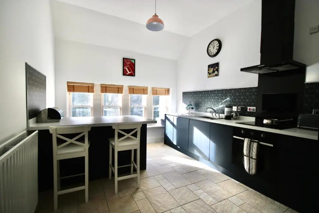 a kitchen with black and white cabinets and a counter at Serviced Accommodation Moray - Lesmurdie House in Elgin