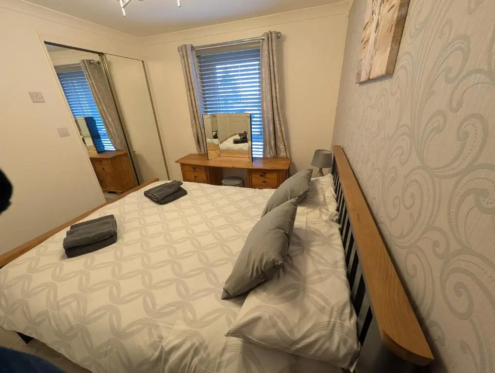 a bedroom with a bed and a mirror at 1 Fulmar Road**Next to West Beach and Golf Course in Lossiemouth