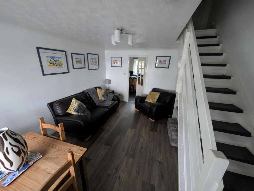 a living room with a couch and a staircase at 1 Fulmar Road**Next to West Beach and Golf Course in Lossiemouth