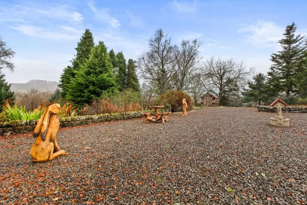 a park with statues of animals on a gravel road at Freuchies Mill - A Holiday Home For All Seasons. in Blairgowrie
