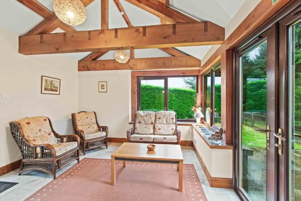 a living room with two chairs and a table at Freuchies Mill - A Holiday Home For All Seasons. in Blairgowrie