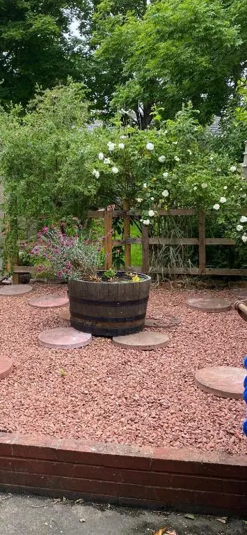 a garden with a large planter with flowers in it at NC500, Wick Caithness Holiday Home in Wick