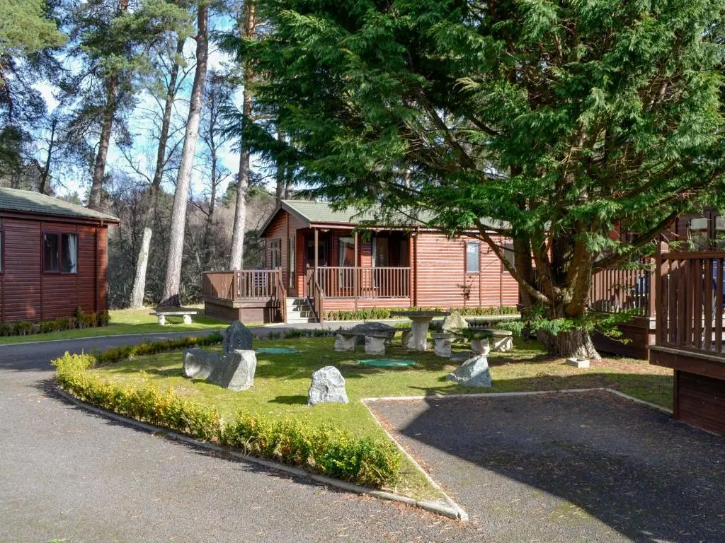 a cabin with rocks in front of a house at Lodge B- Uk33087 in Dinnet