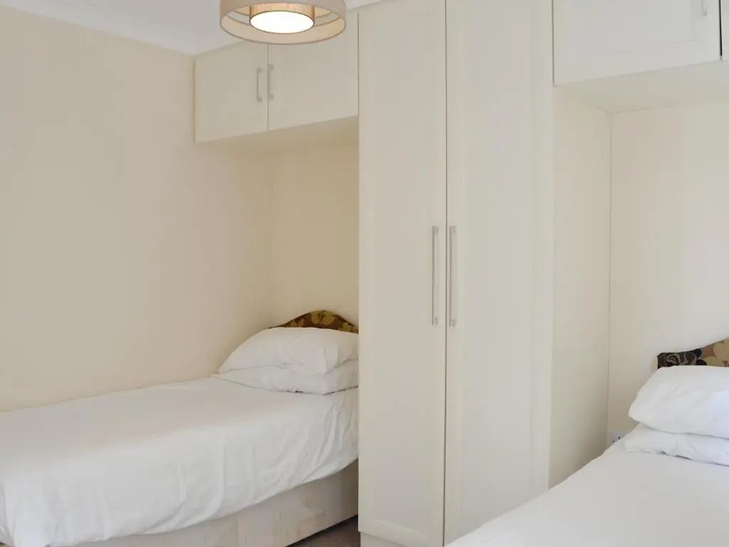 a bedroom with white cabinets and a bed at Lodge D- Uk33090 in Dinnet