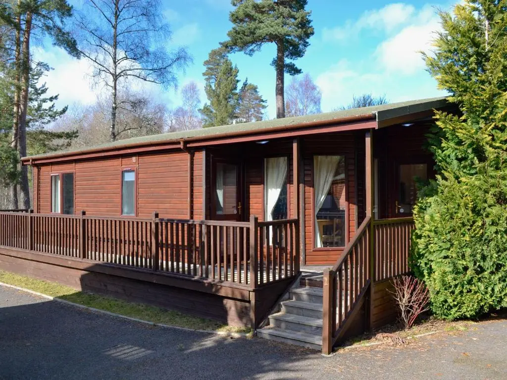 a log cabin with a porch and stairs to it at Lodge A- Uk33088 in Dinnet