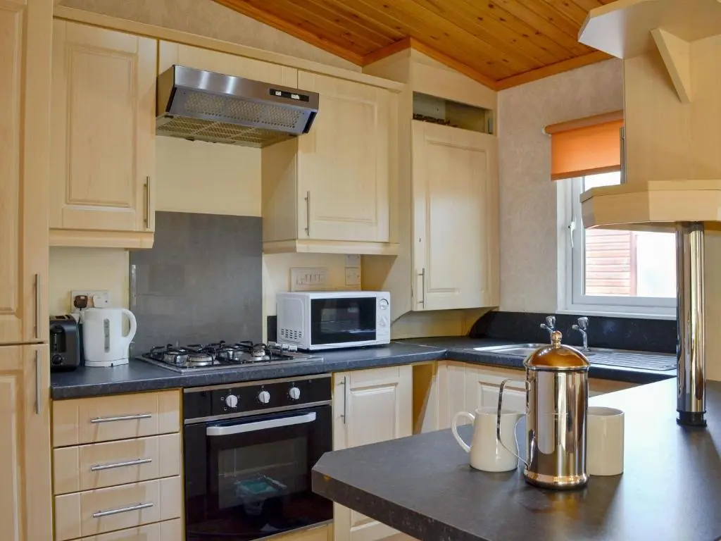 a kitchen with a stove and a microwave at Lodge A- Uk33088 in Dinnet