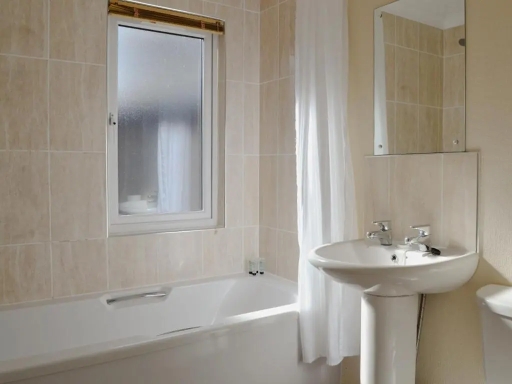 a bathroom with a sink and a bath tub and a sink at Lodge G- Uk33093 in Dinnet