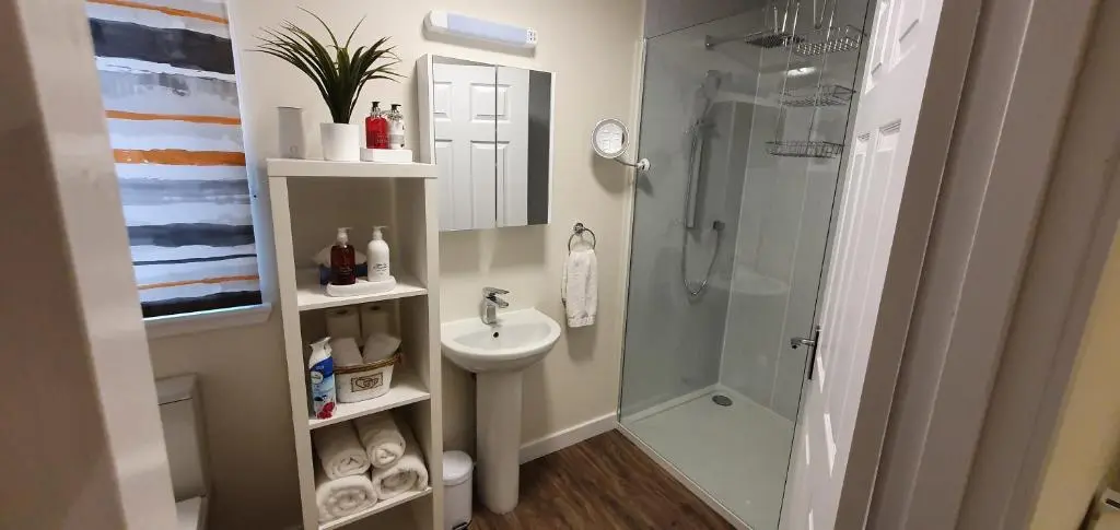 a bathroom with a glass shower and a sink at Meadows 2 in Auldearn