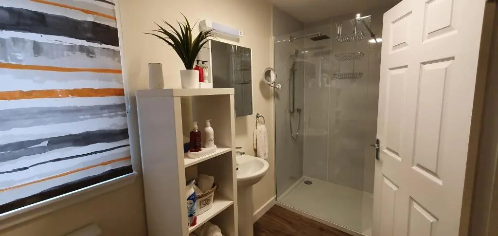 a bathroom with a shower and a toilet and a sink at Meadows 2 in Auldearn