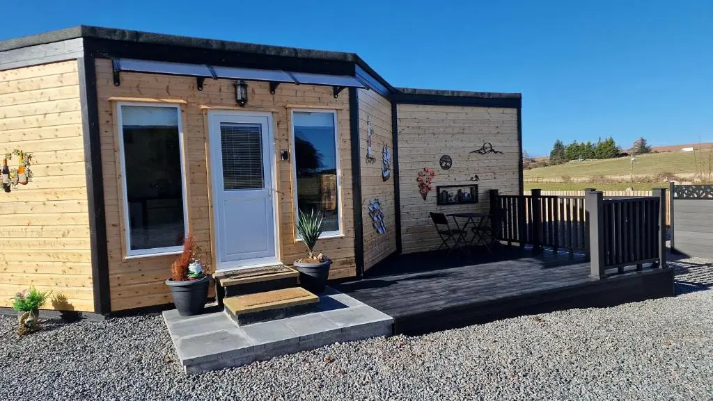 a tiny house with a porch and a door at Meadows 2 in Auldearn