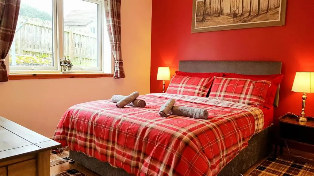a red bedroom with a bed with two teddy bears on it at Hill View 2 bedroom free parking in Inverness