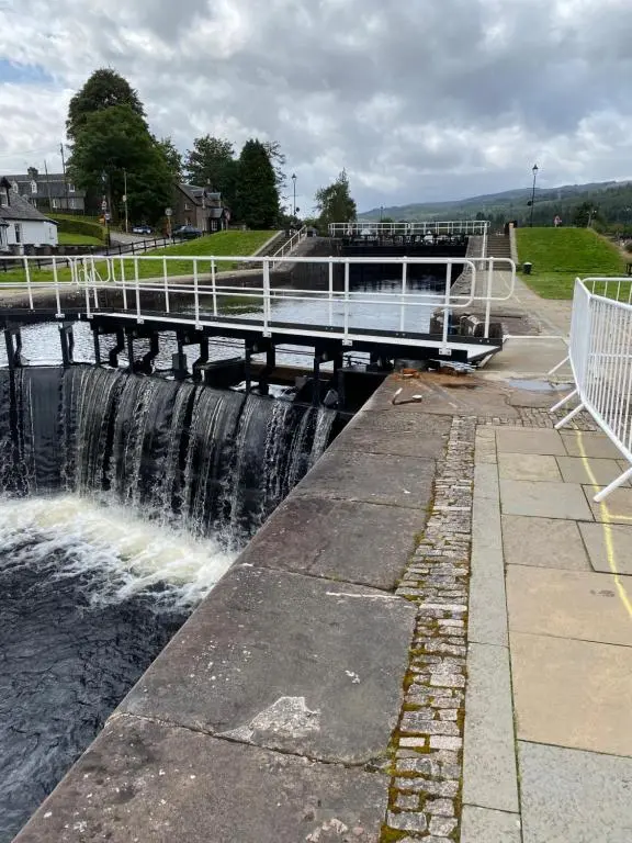 a bridge over a river with a waterfall at Hayfield lodge in Spean Bridge