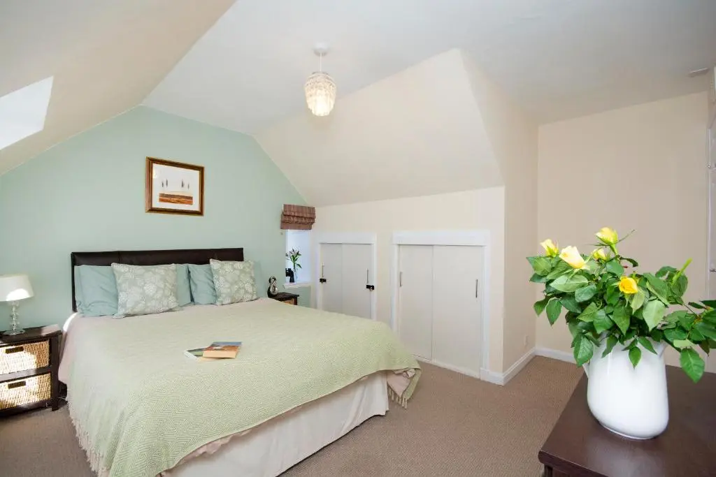 a bedroom with a bed and a vase of flowers at Finest Retreats - Ellie-Jo Cottage in Gardenstown