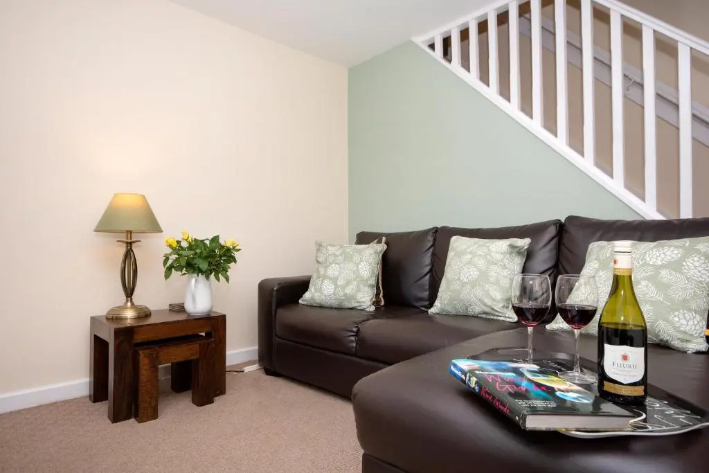 a living room with a brown couch and wine glasses at Finest Retreats - Ellie-Jo Cottage in Gardenstown