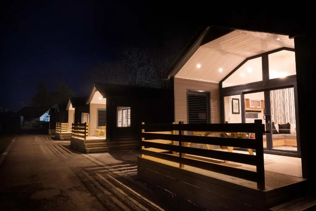 a house with a fence in front of it at night at 2 Bed Self-Catering Lodge Inverness - Sleeps 4 in Inverness