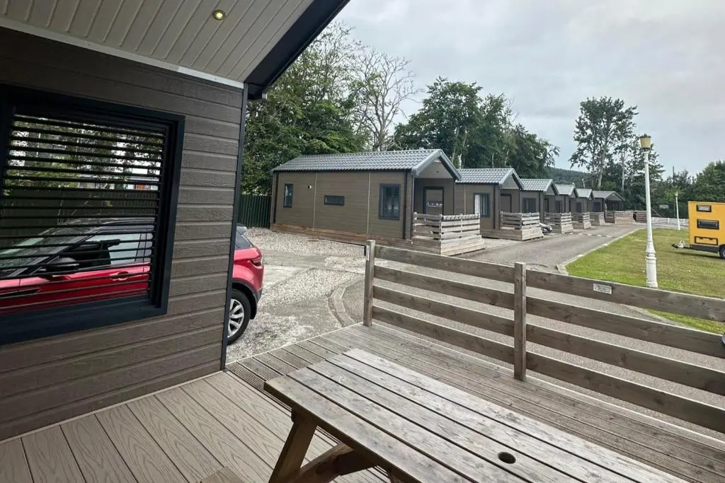 a wooden bench sitting on the side of a building at 2 Bed Inverness - Sleeps 4 - Parking - Wifi in Inverness