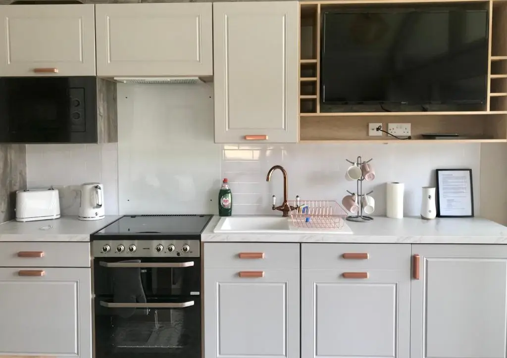 a kitchen with white cabinets and a sink at 2 Bed Inverness - Sleeps 4 - Parking - Wifi in Inverness