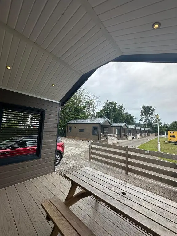 a wooden bench sitting on the porch of a building at 2 Bed Lodge - Sleeps 4 - Parking - Wifi in Inverness