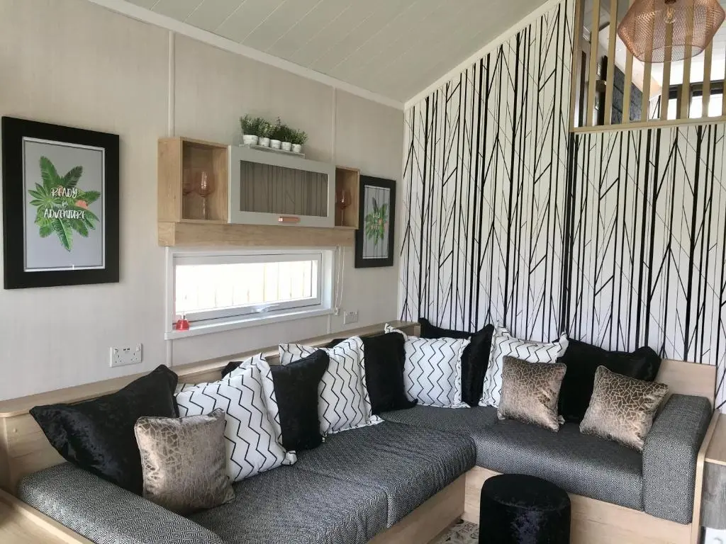 a living room with a gray couch with pillows at Self-Catering Lodge with Hot Tub in Inverness