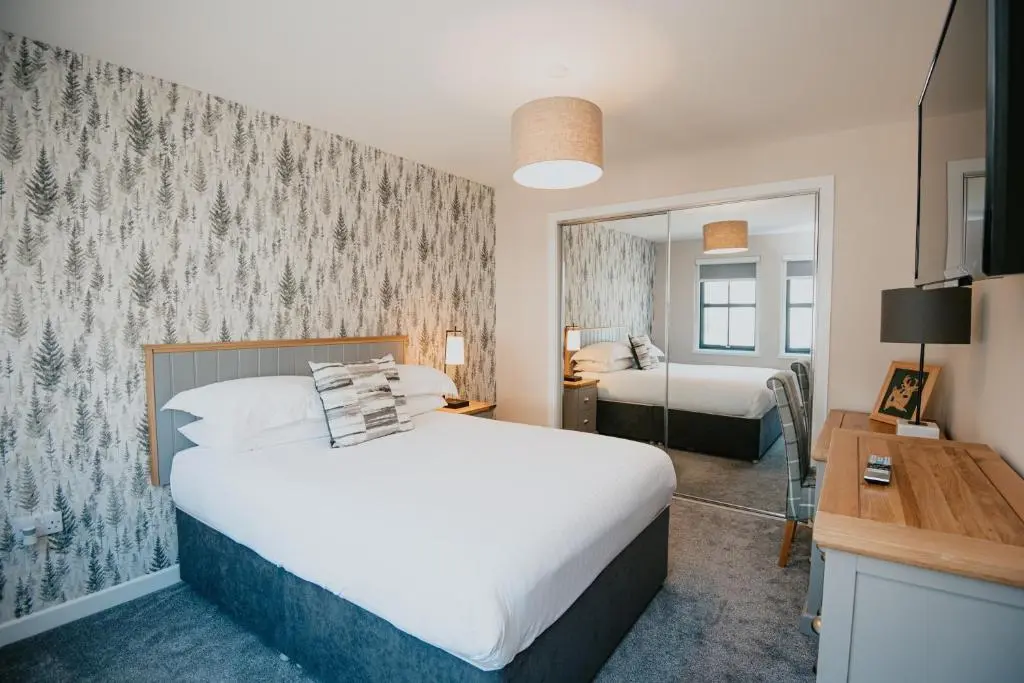 a bedroom with a large bed and a mirror at The Seafield Arms Hotel Cullen - Self Catering in Cullen