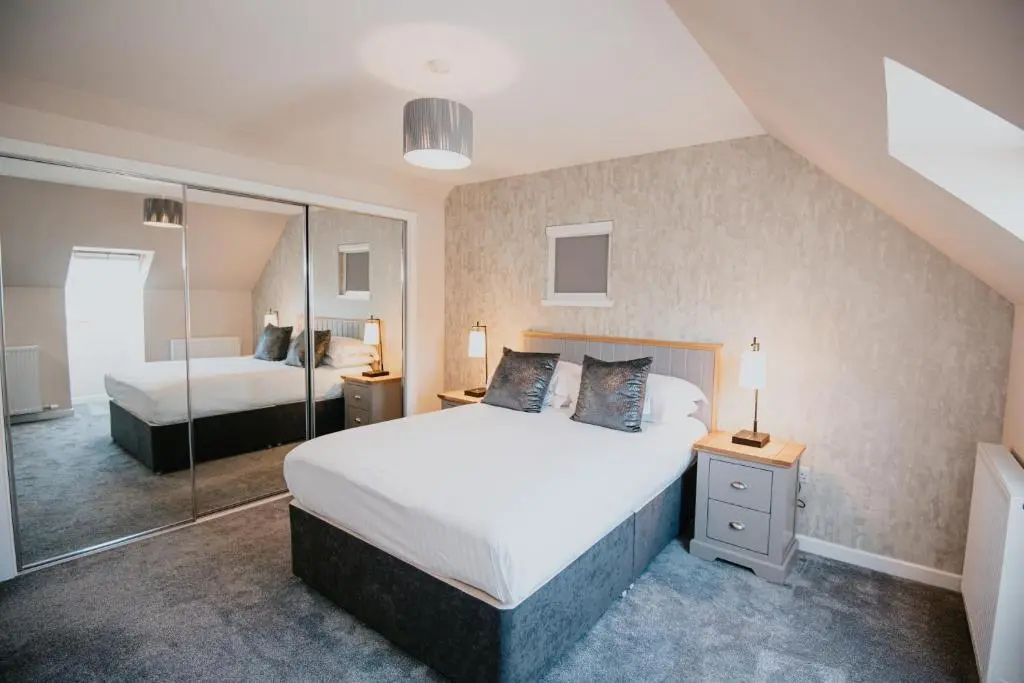 a bedroom with two beds and a mirror at The Seafield Arms Hotel Cullen - Self Catering in Cullen