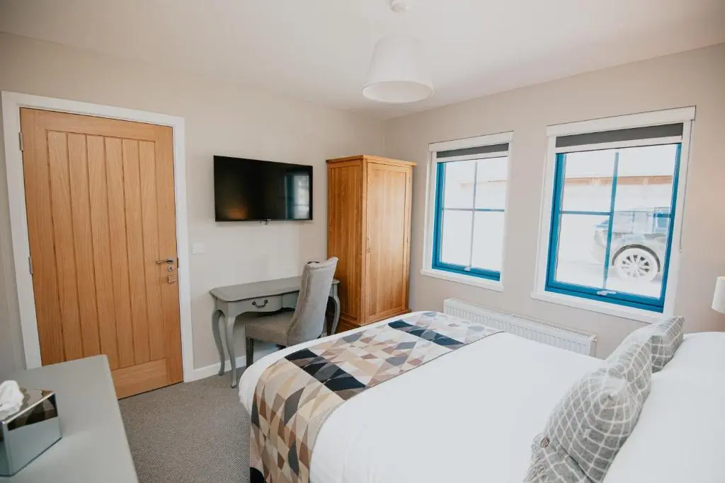 a bedroom with a bed and a desk with a computer at The Seafield Arms Hotel Cullen - Self Catering in Cullen