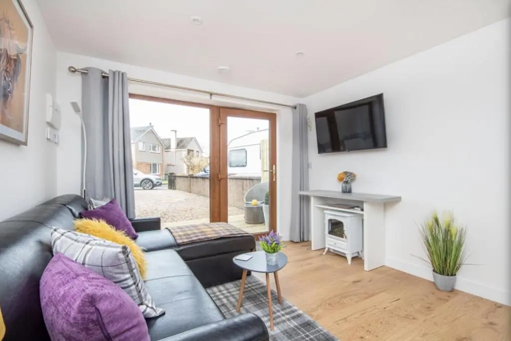 a living room with a couch and a fireplace at The Nook in Inverness
