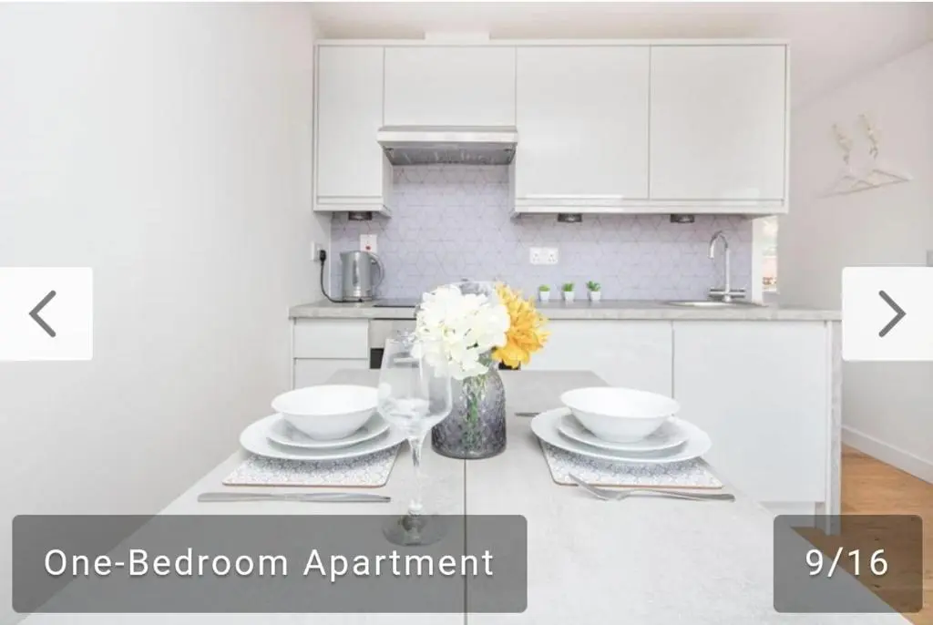 a white kitchen with a vase of flowers on a counter at The Nook in Inverness
