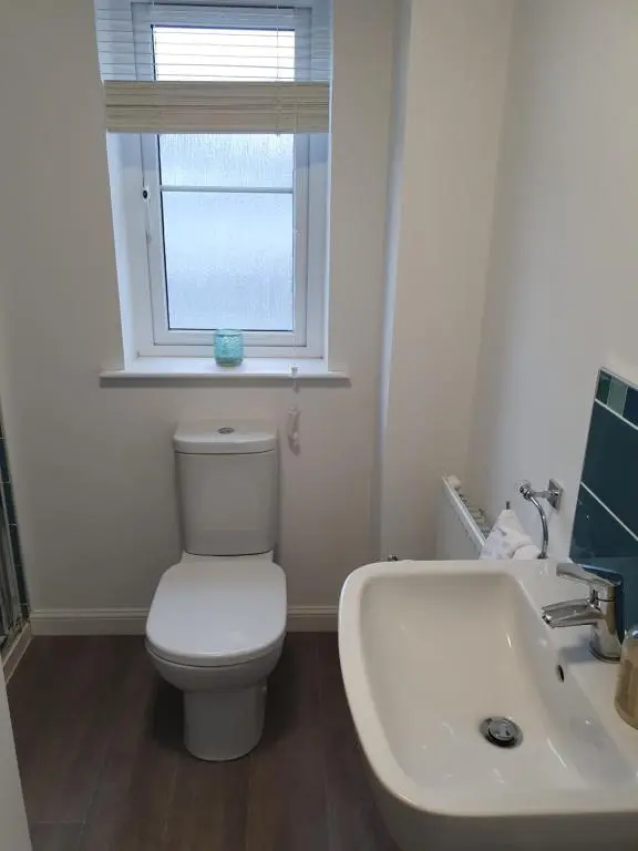 a bathroom with a toilet and a sink and a window at Kellys in Inverness