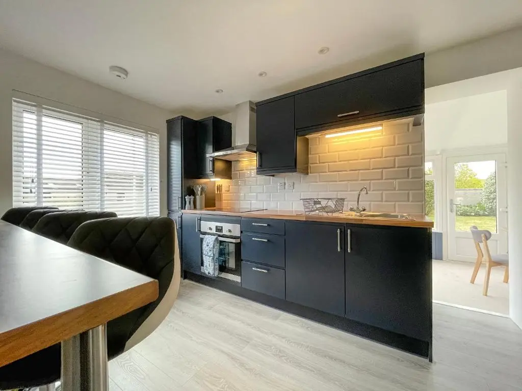 a kitchen with black cabinets and a counter top at Iseabail's House in Balintore